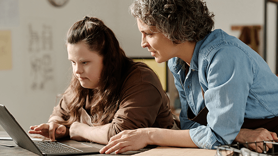 parent and youth worker looking at resources on a laptop 