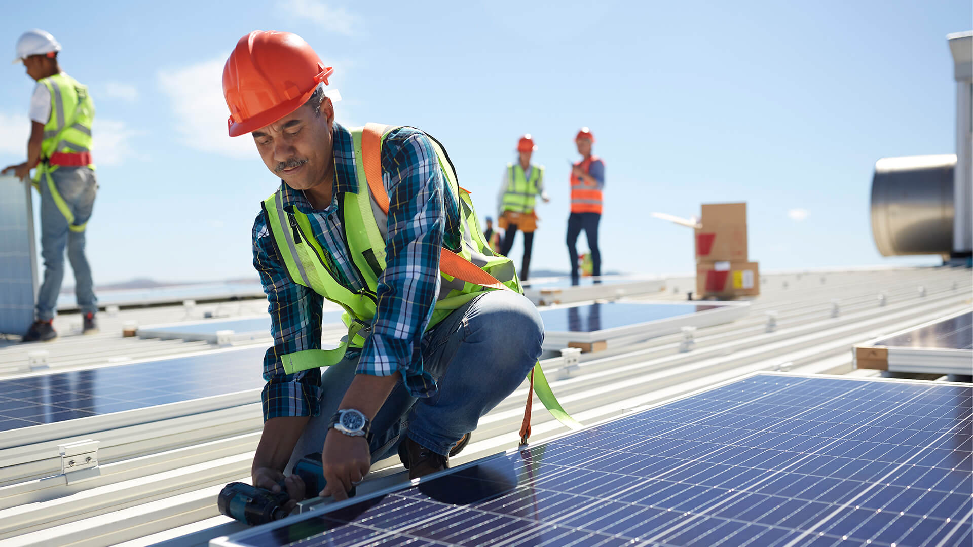 Workers installing solar panels on a commercial rooftop.