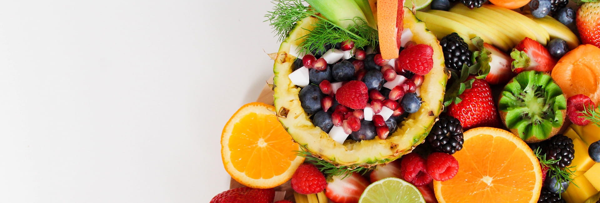 Arrangement of mixed fruits of pineapple, blueberries, raspberries, oranges and kiwi
