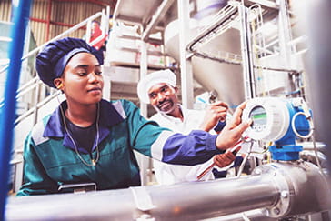 Workers checking gauges on food processor