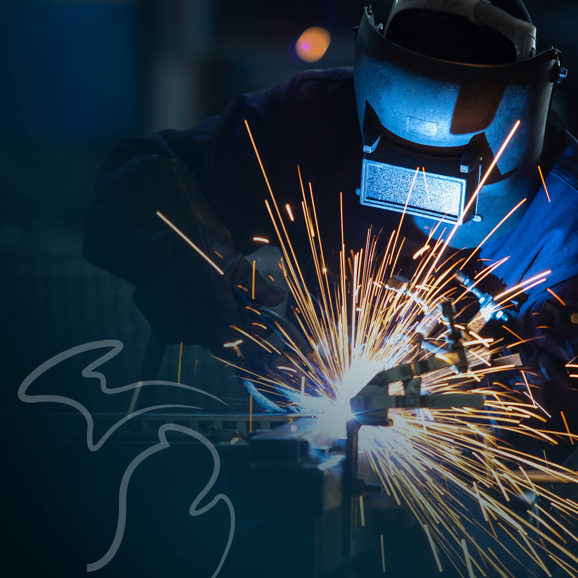 A metal worker wearing a welding mask and fusing metal parts together while bright sparks emit outward from a torch.