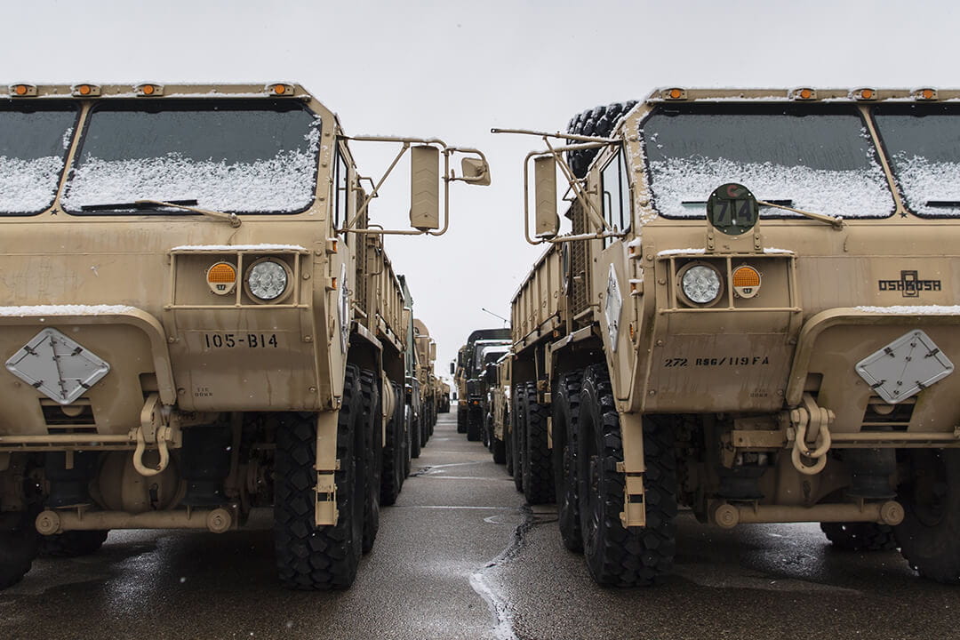 Rows of U.S. Army military transport trucks staged by Soldiers from the 46th Military Police Company stand ready for training and demonstrations in Lansing, Michigan.