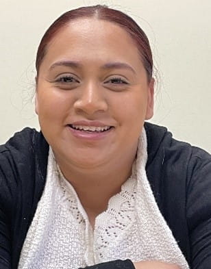 Julisa, a Latino woman in a white shirt and cardigan smiling