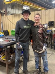 St. Joseph County ISD apprentices Jak and Blake with their arms around each other in a workshop.