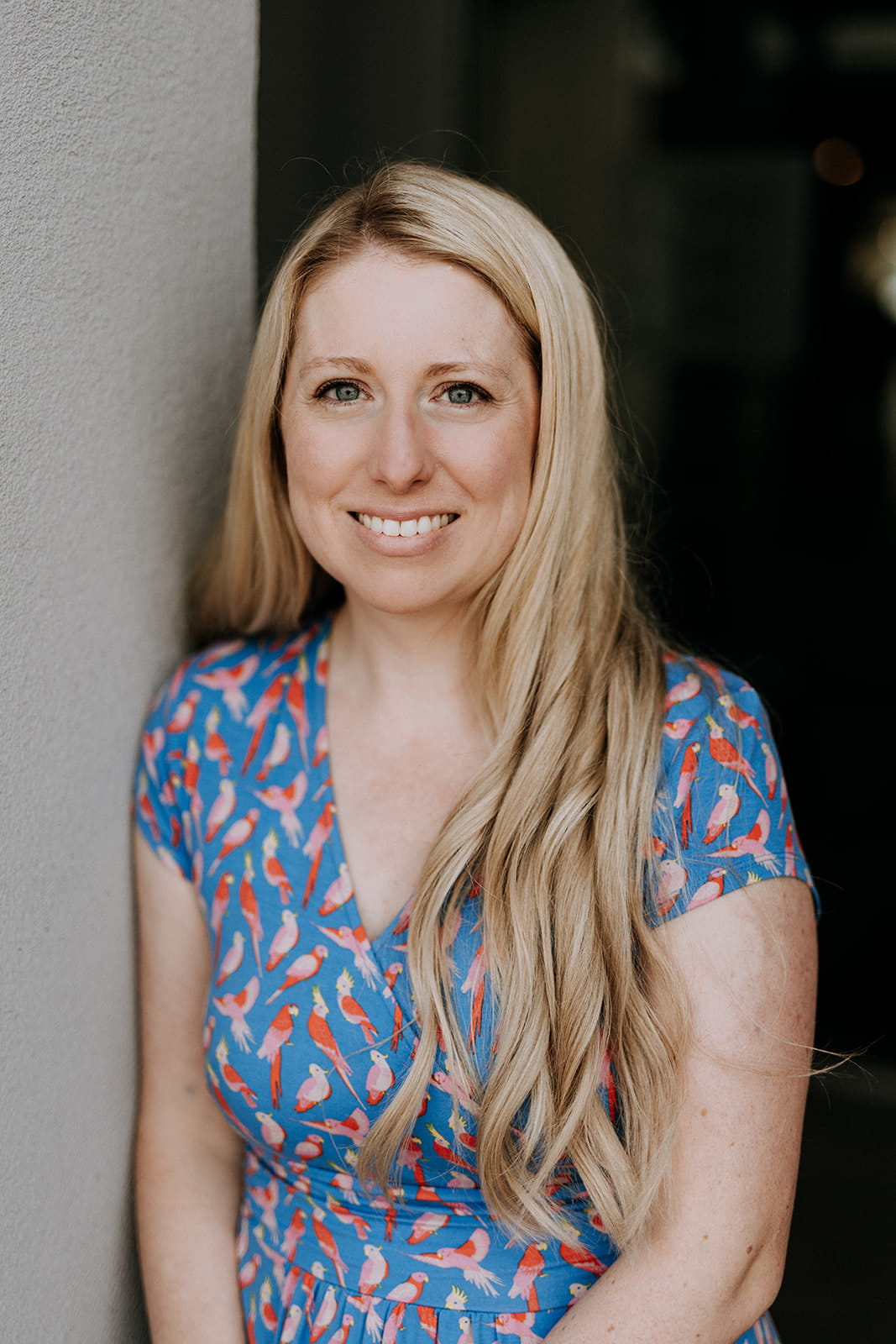 Amy Burns, a young, white woman with blonde hair wearing a blue shirt with birds on it.