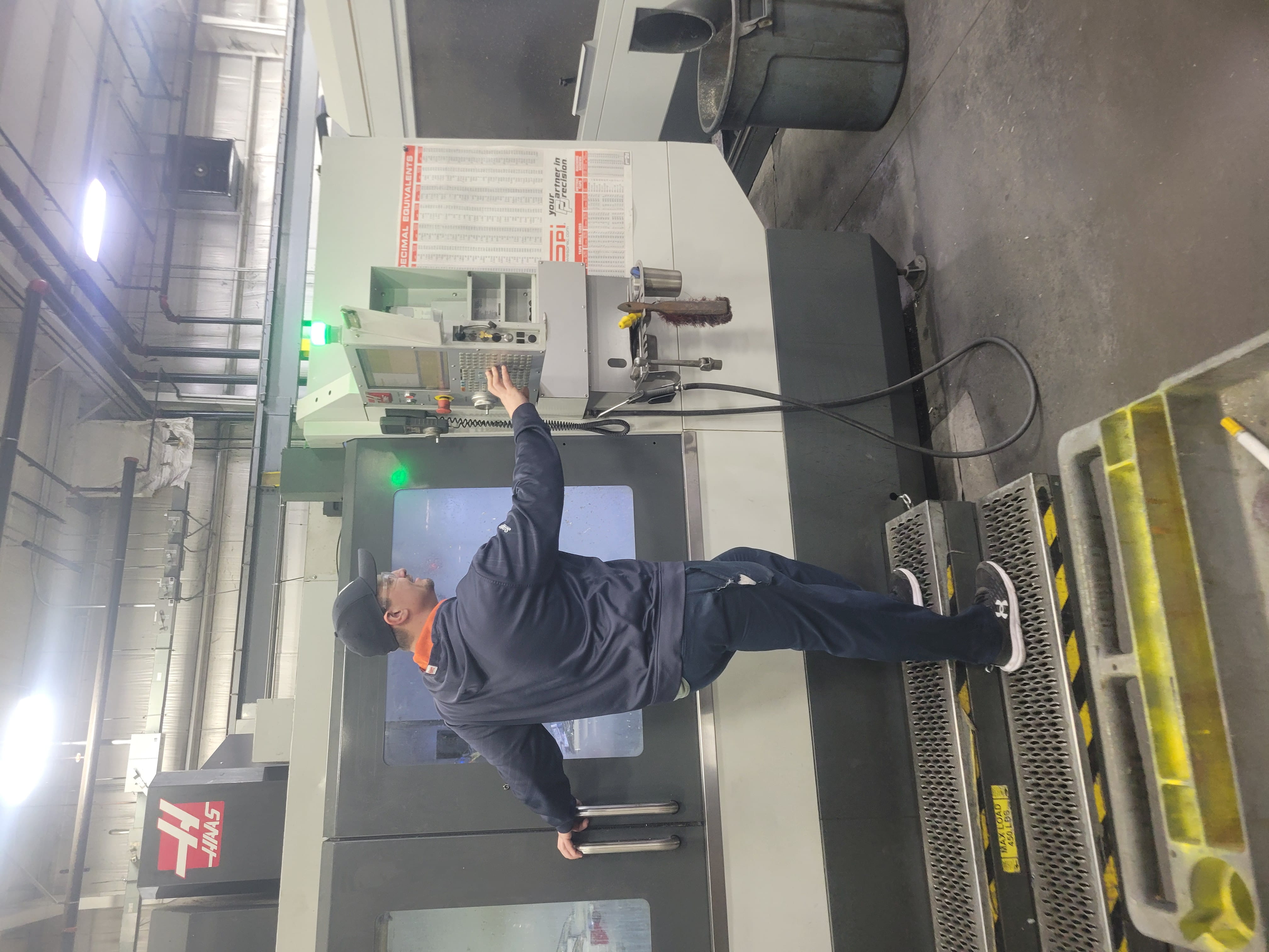 Brandon operating a machine with his back to the camera.