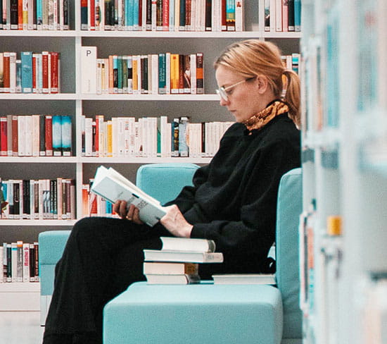 Woman reading book in library