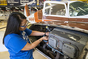 woman working on plane engine
