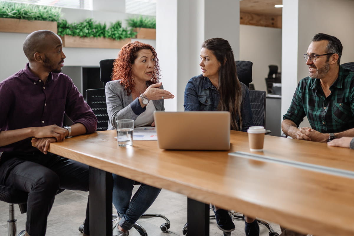 A diverse team of professionals gathered around a conference table and engaged in discussion.