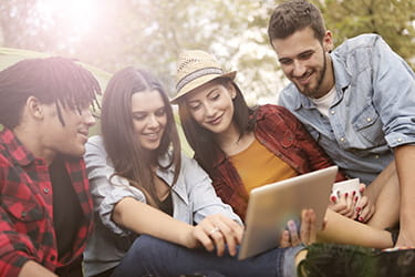 Cheerful woman showing friends video on tablet
