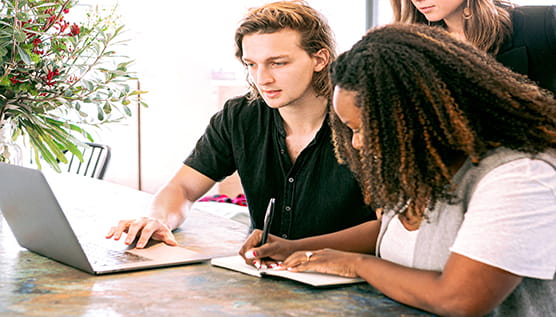 Man showing woman laptop 