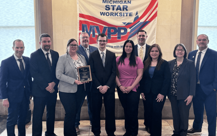Group photo of MIOSHA and Cintas Westland employees holding an MVPP Star recognition plaque.