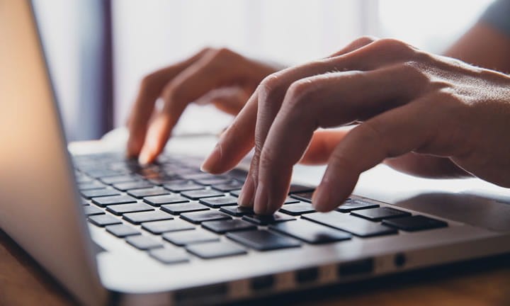 hands typing on a computer