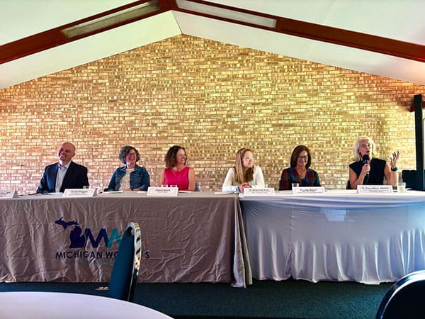 Midland menopause event panel sitting at panel table while one presents