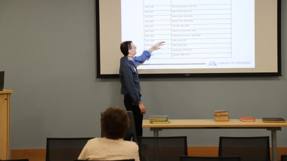 Instructor in front of projector display