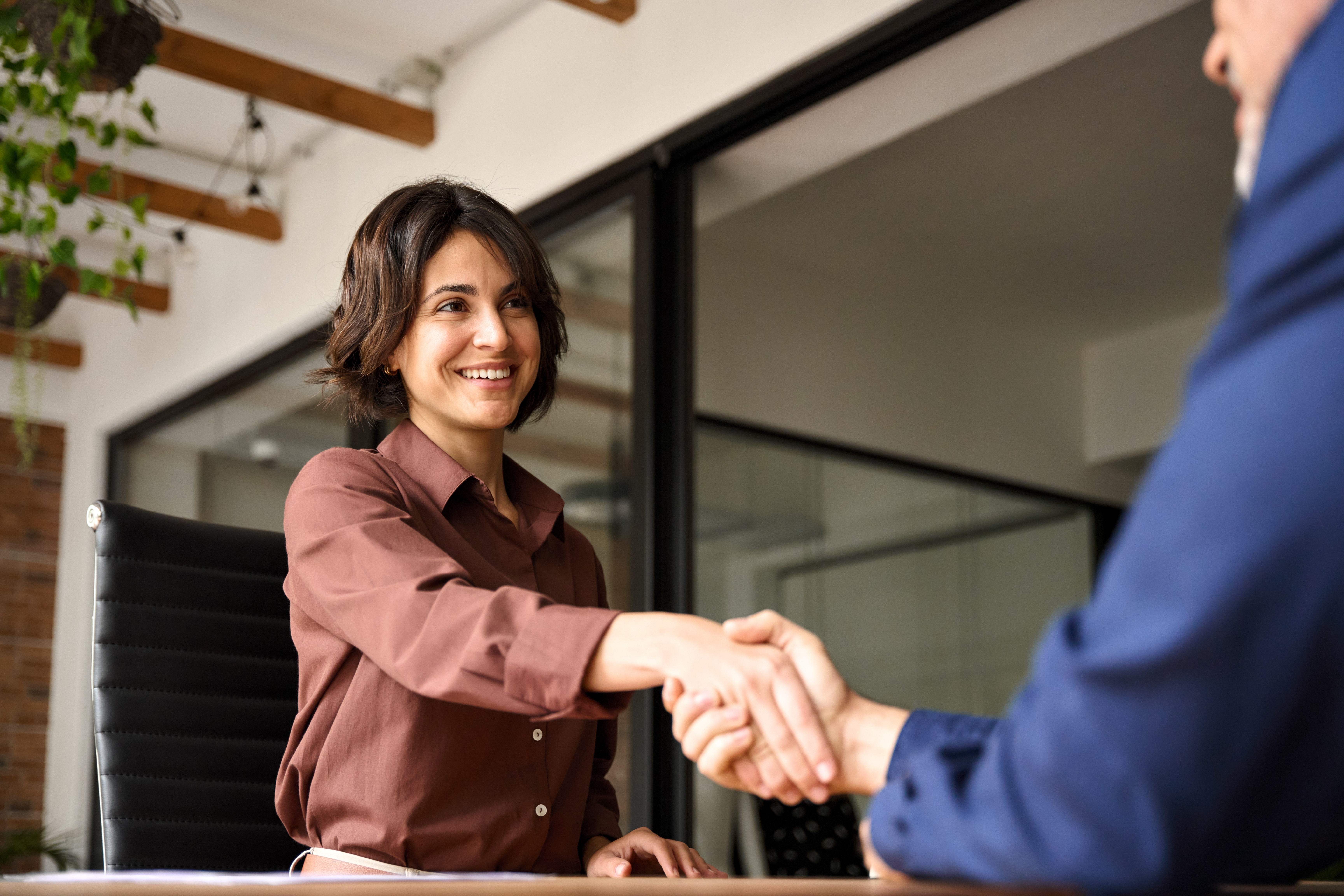 woman shaking hands with a man in a business setting