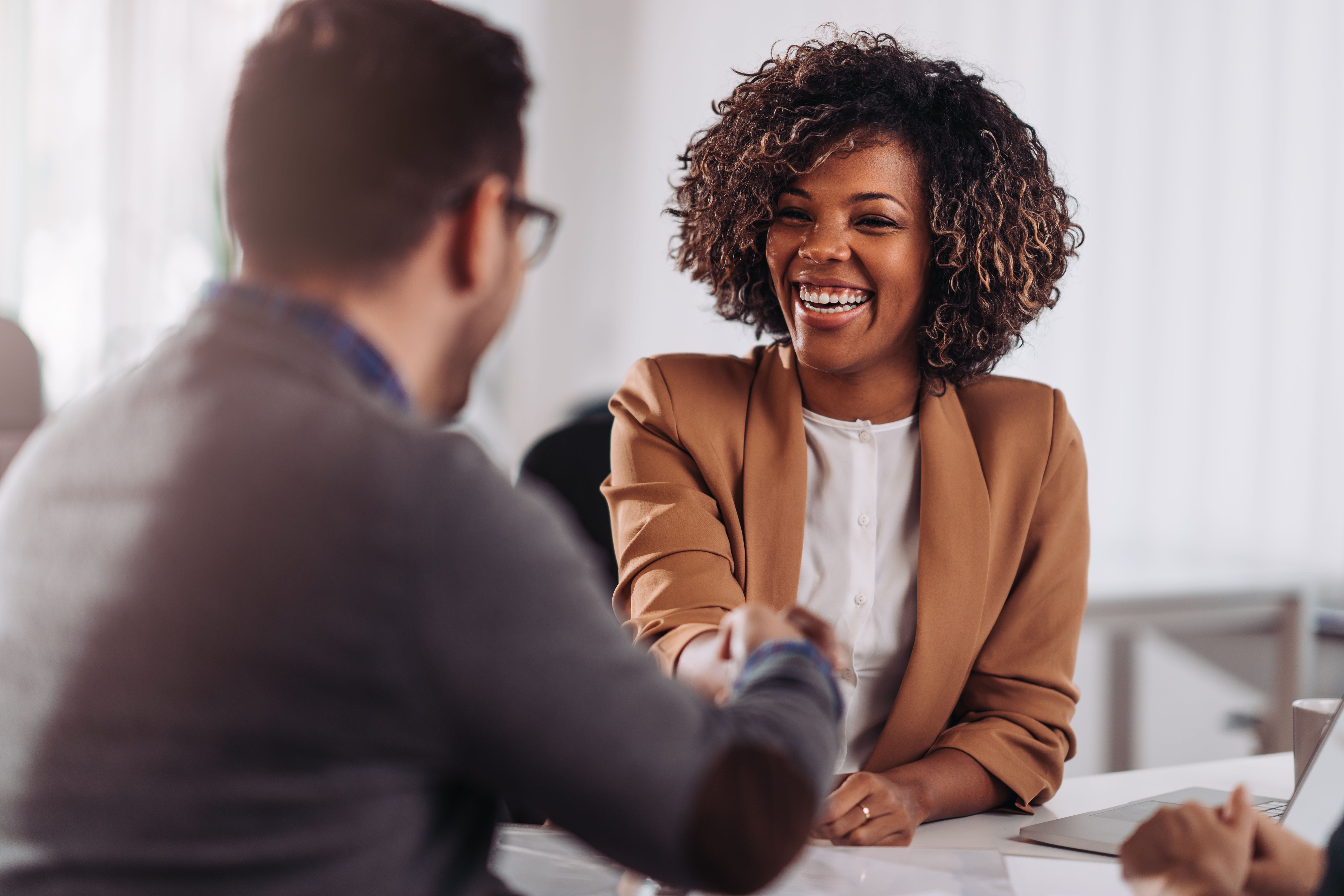 man and woman shaking hands in an office