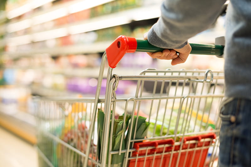 person pushing a cart in a grocery store