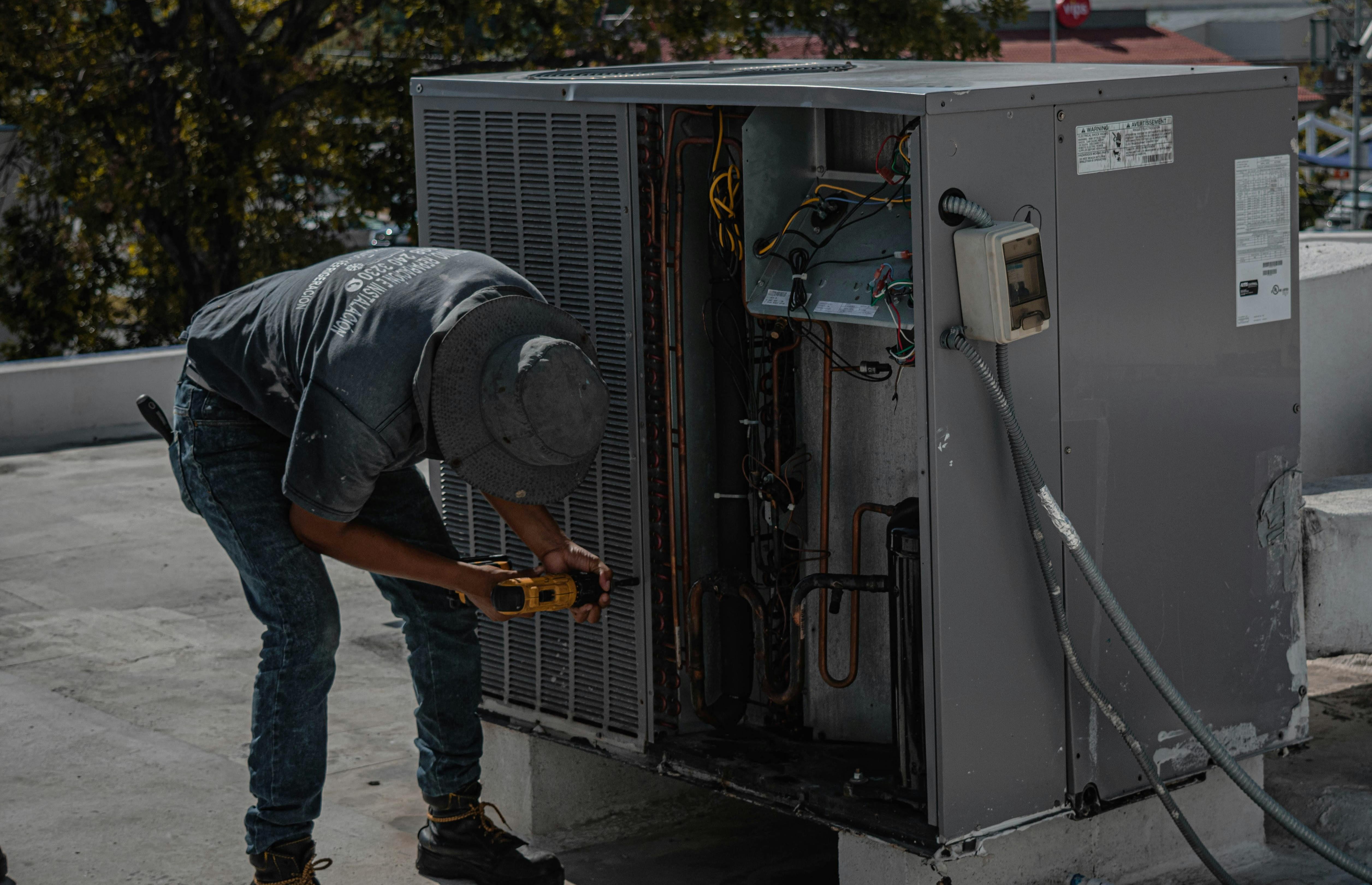 A man working on an air conditioning unit.