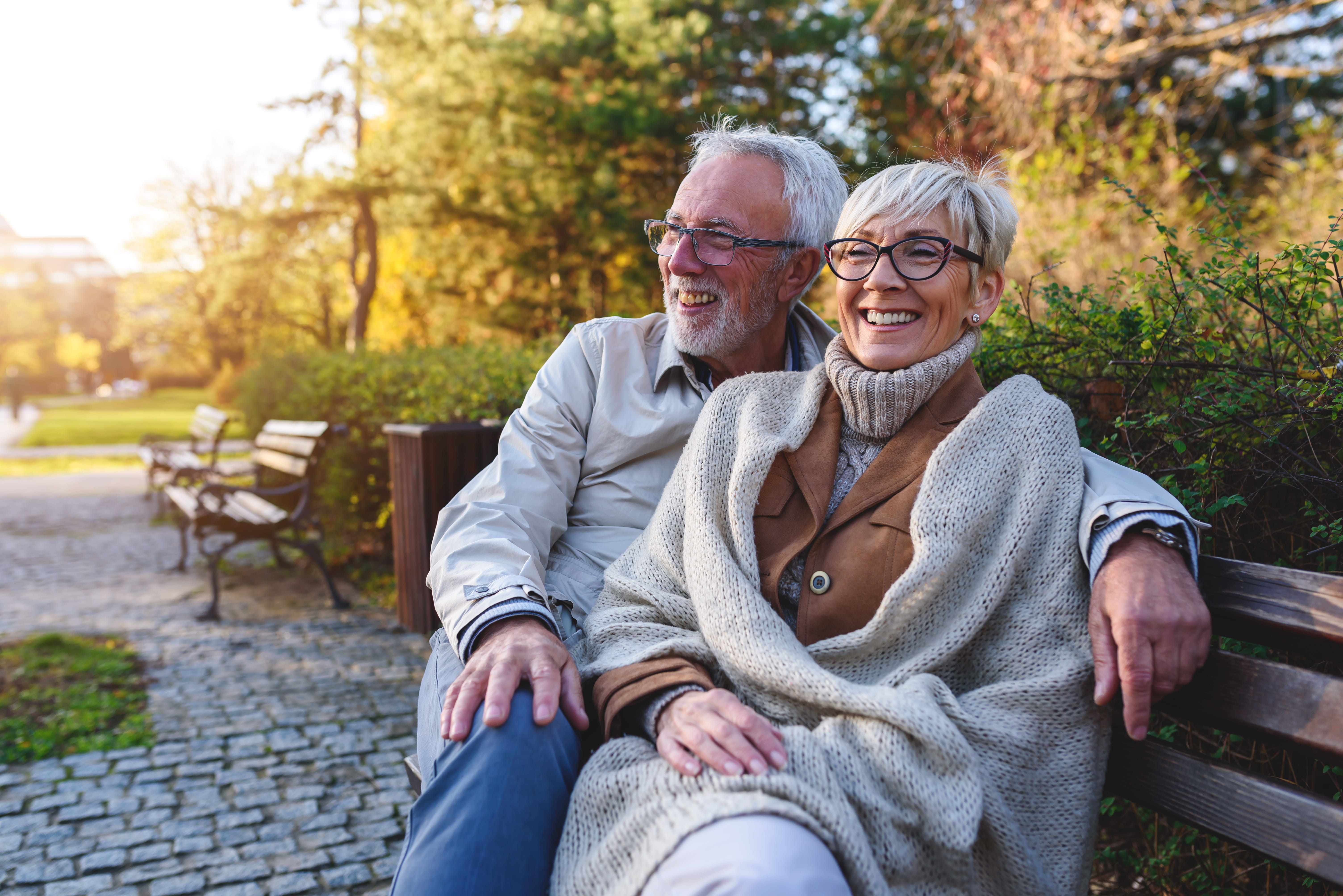 retirement-age couple sitting on a bench outdoors
