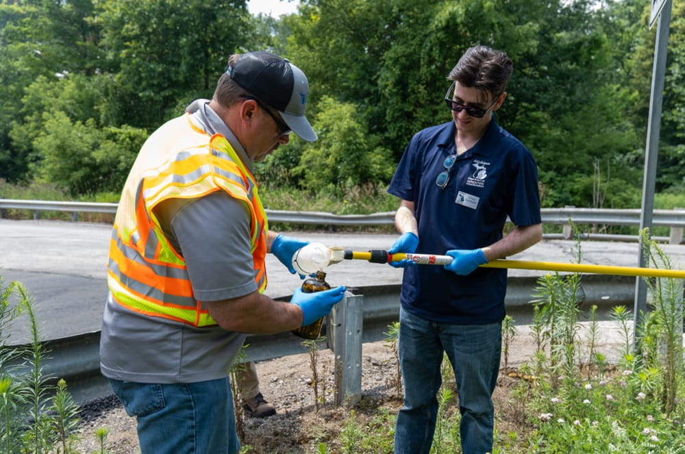 The sample team is wearing person protective gear and testing chemicals.