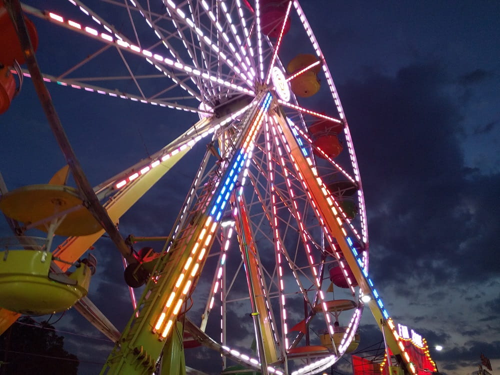 Nighttime view of a brightly colored ferris wheel lit up