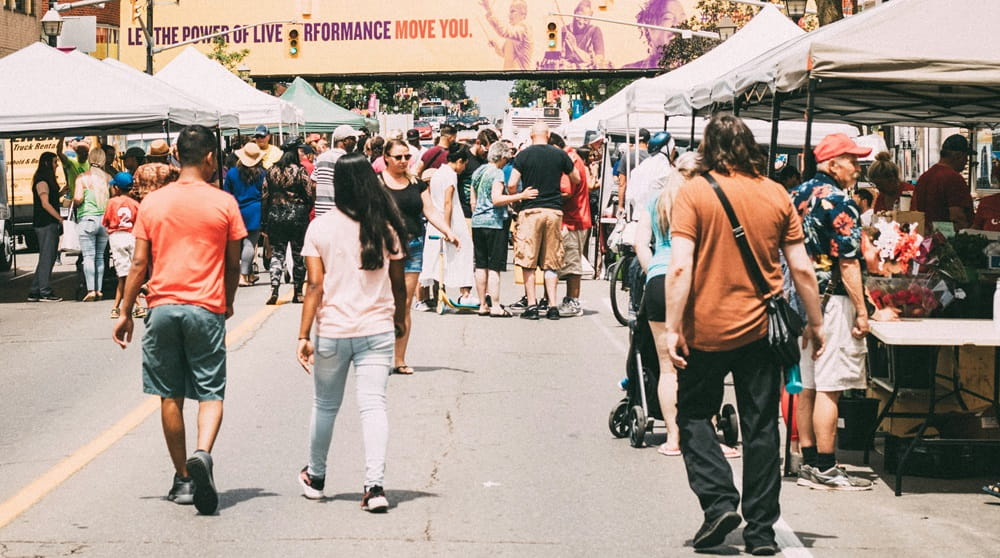 People wandering through food tents at a street festival