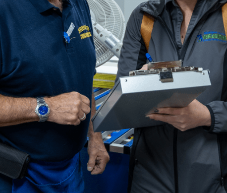 Two people inspecting a clipboard.