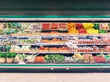 Refrigerated shelves stocked with fresh and frozen food at a supermarket