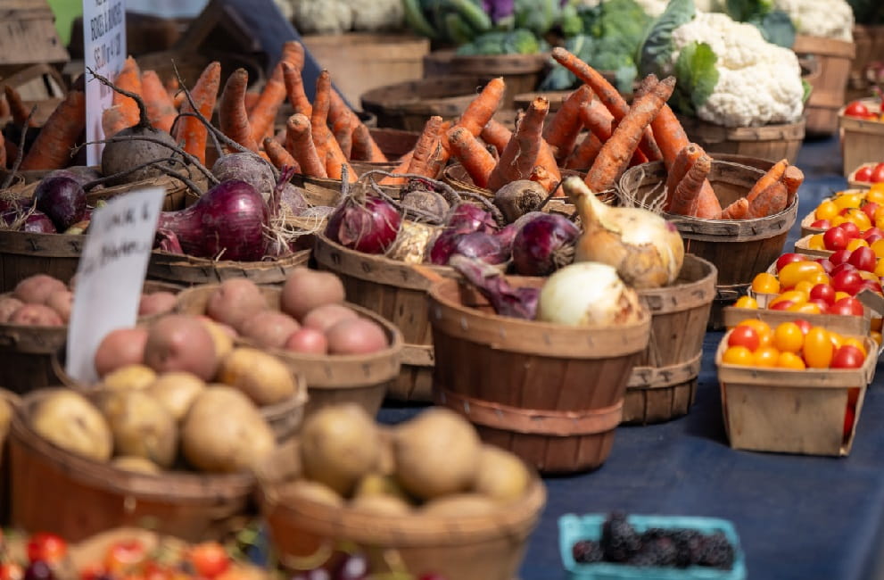 A variety of root vegetables at a farmers market.