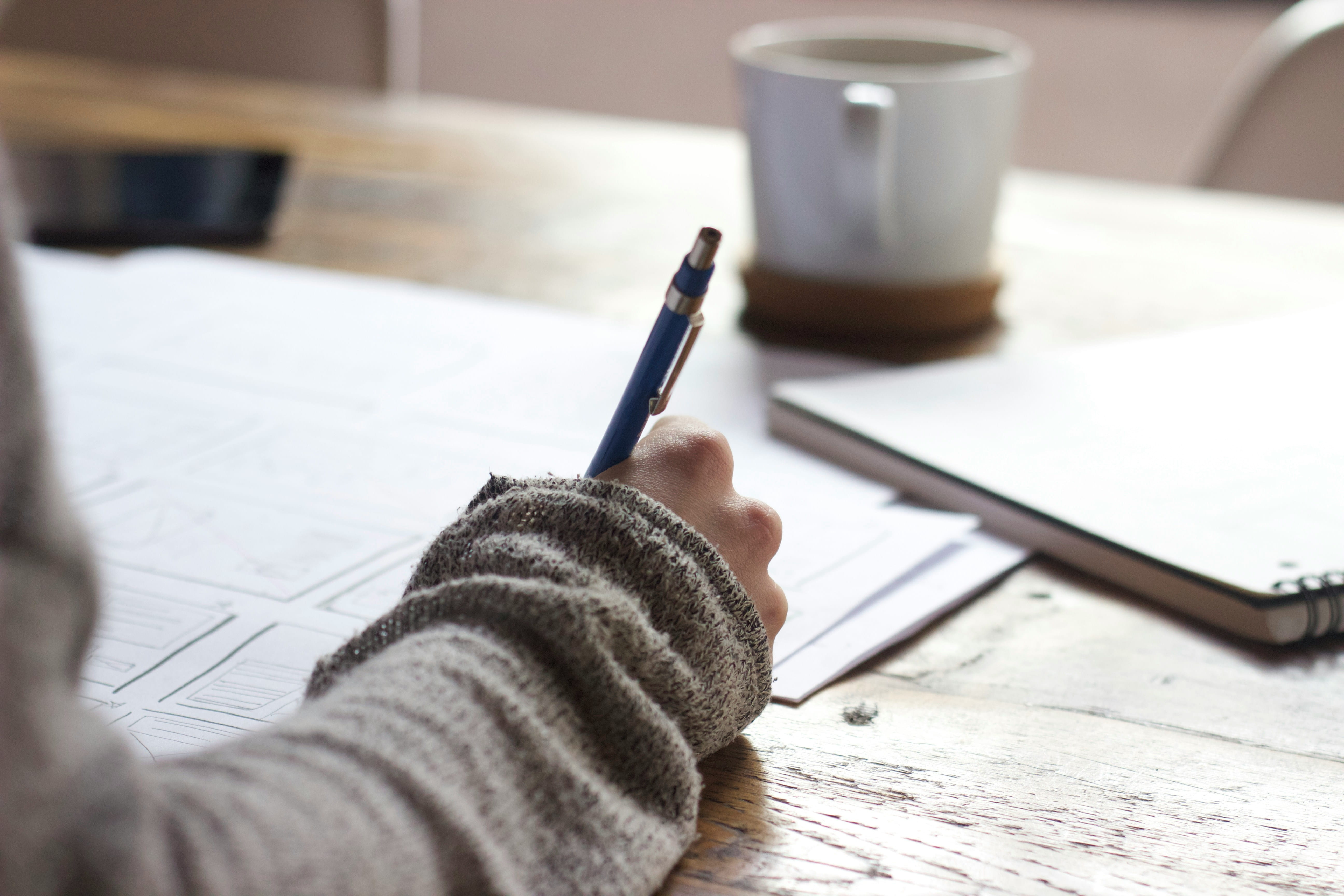 A designer is sketching plans on a piece of paper