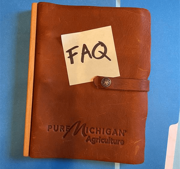 A notebook with a note on it that says "FAQ".
