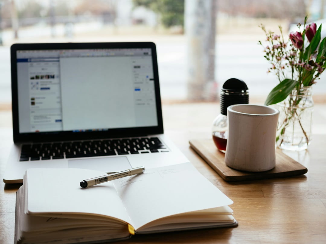 An open laptop near an open book
