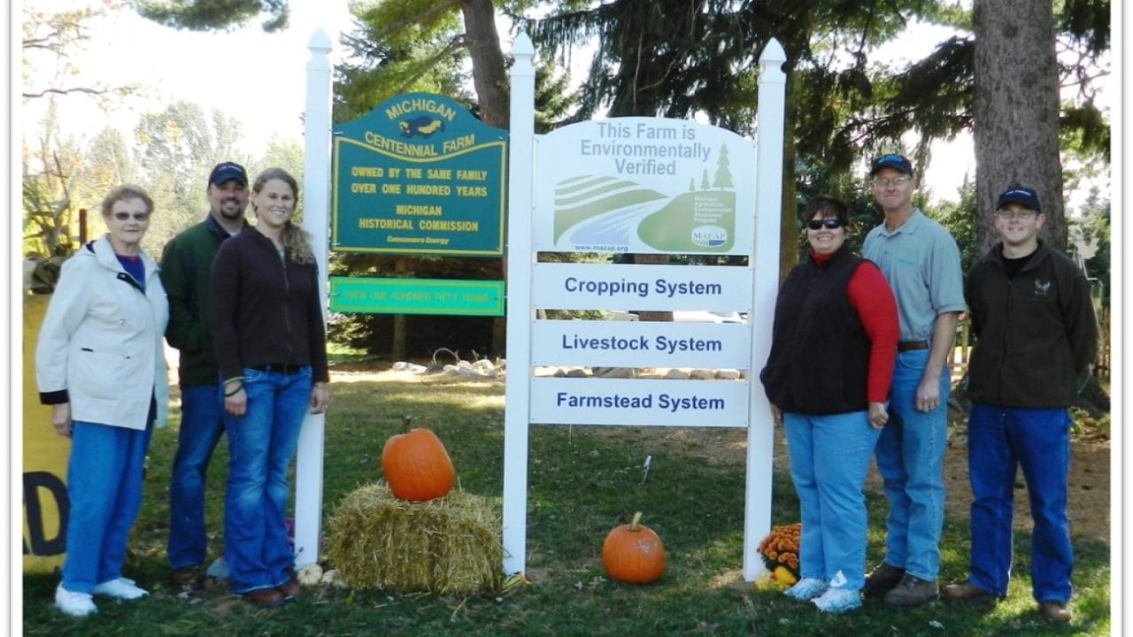 Six members of the Lee family standing around pumpkins with a MAEAP verified sign