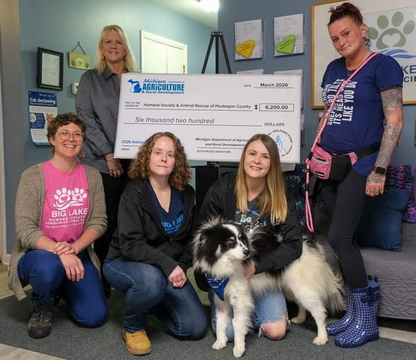 MDARD employees posing with dog and check.