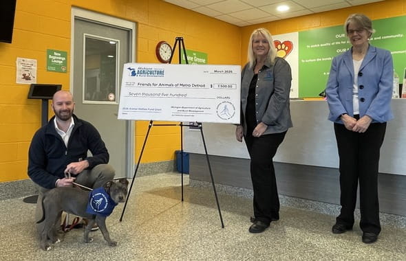 MDARD employees posing with dog and check at animal shelter.