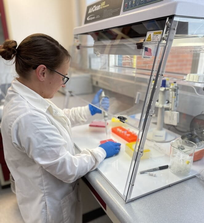 a person in a lab coat studying beans