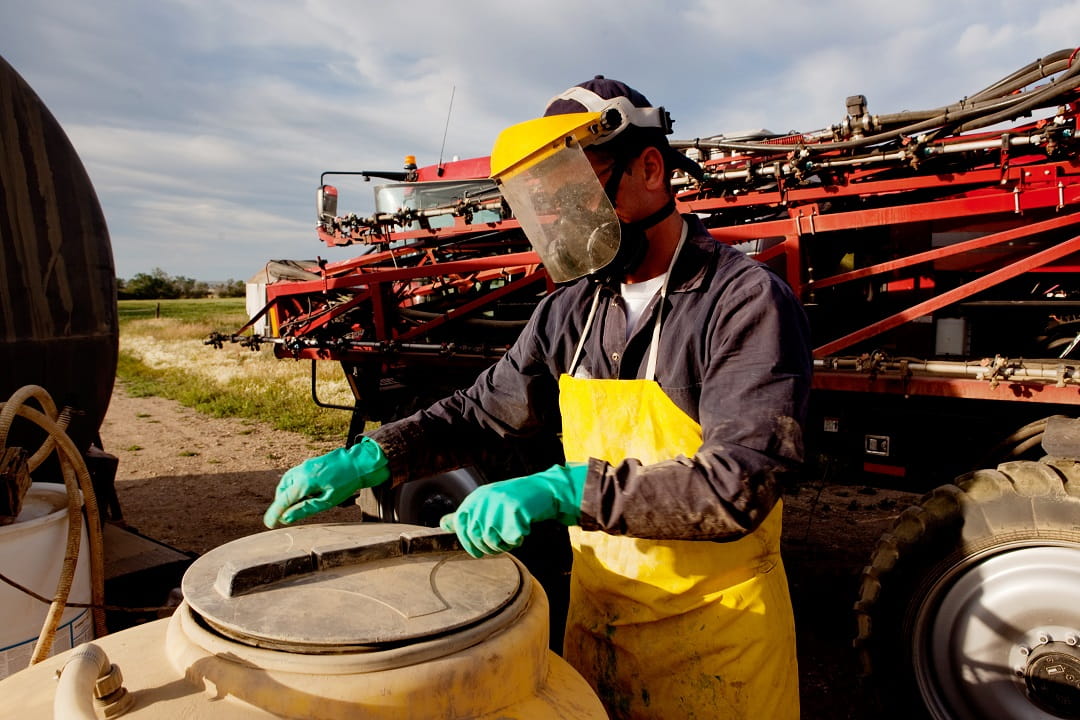 Pesticide applicator in personal protective equipment