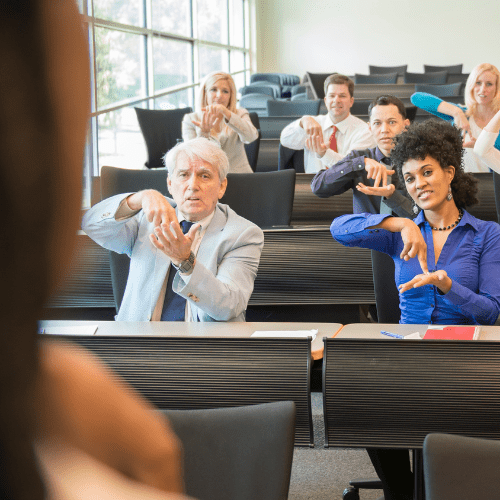 Classroom with multiple individuals using American Sign Language to communicate