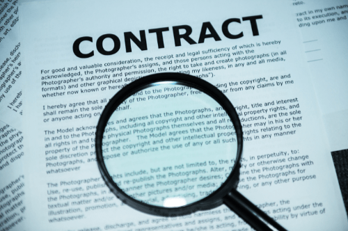 Image of a blurry contract with a magnifying glass