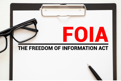 Photo of a clip board and glasses. Clip board contains the text "FOIA. The Freedom of Information Act.
