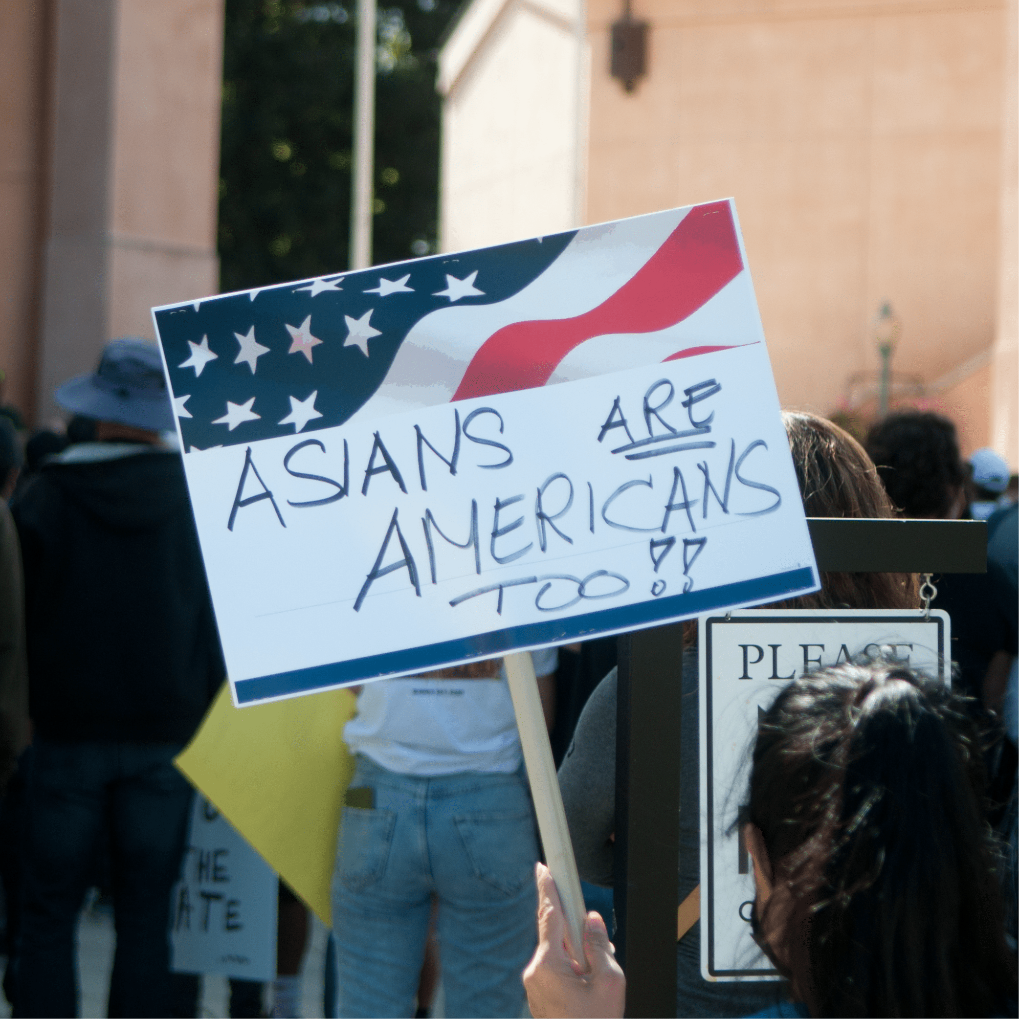 Group of people with protest sign: "Asians are Americans Too"