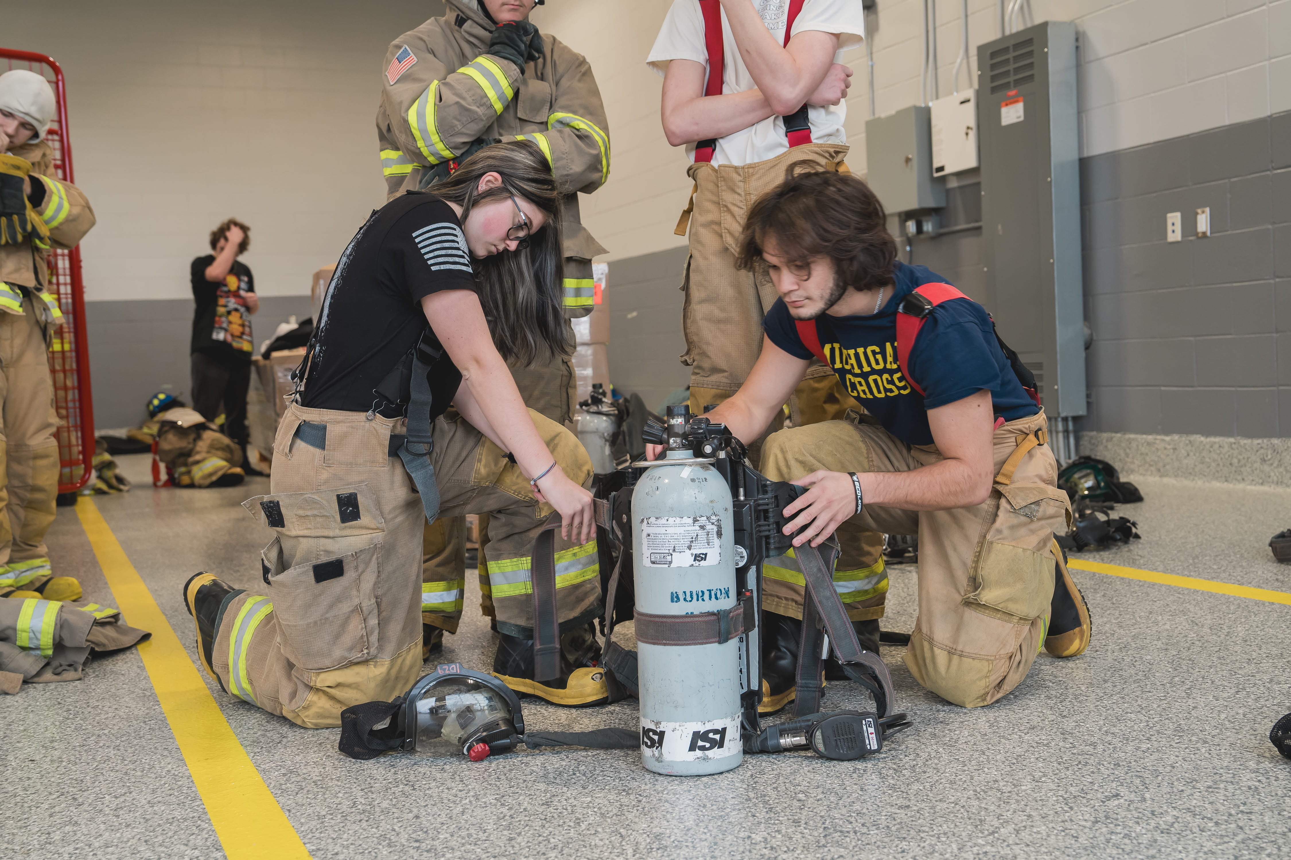 Firefighting students working with equipment. 