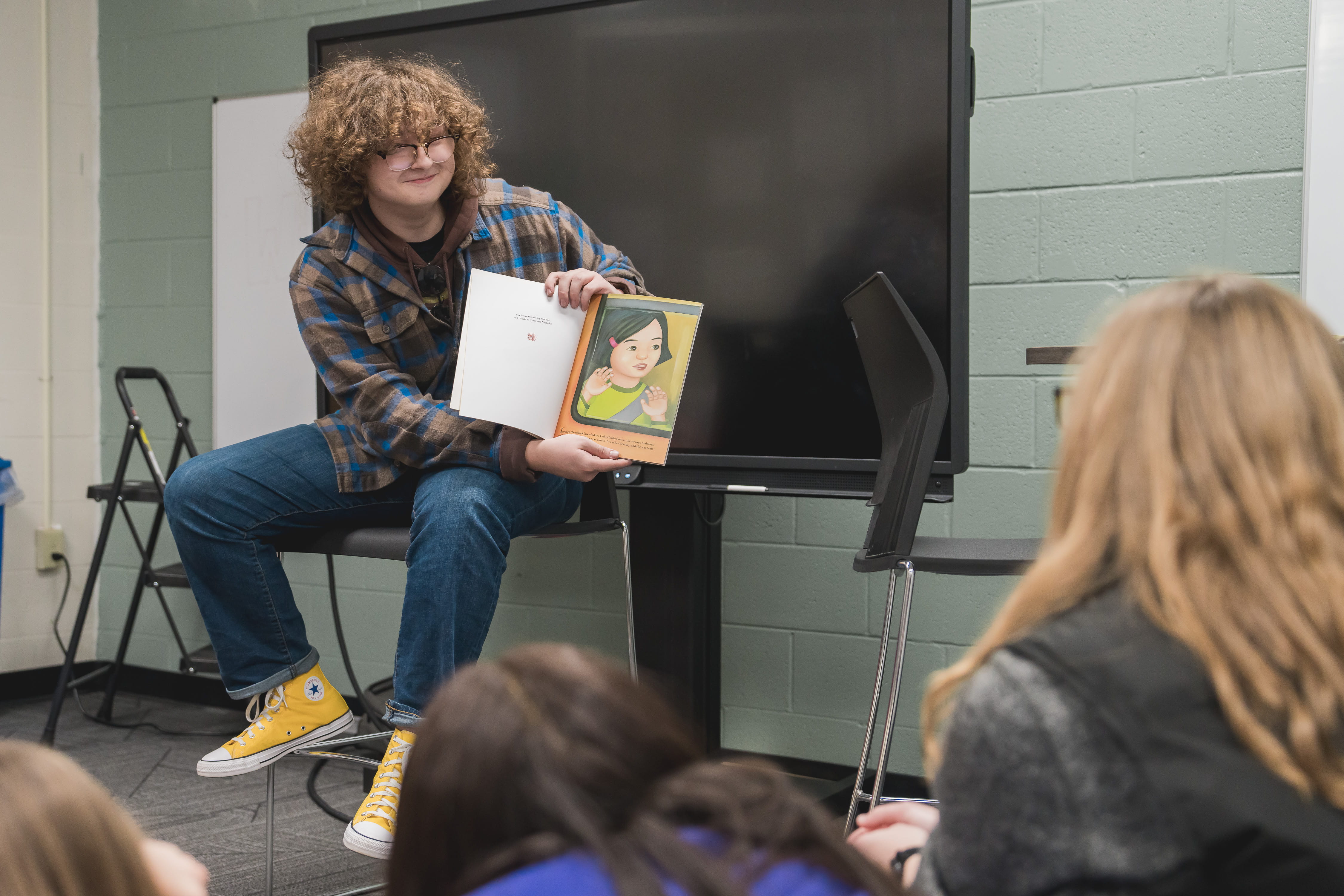 CTE Student reading a book to a class in an education class. 