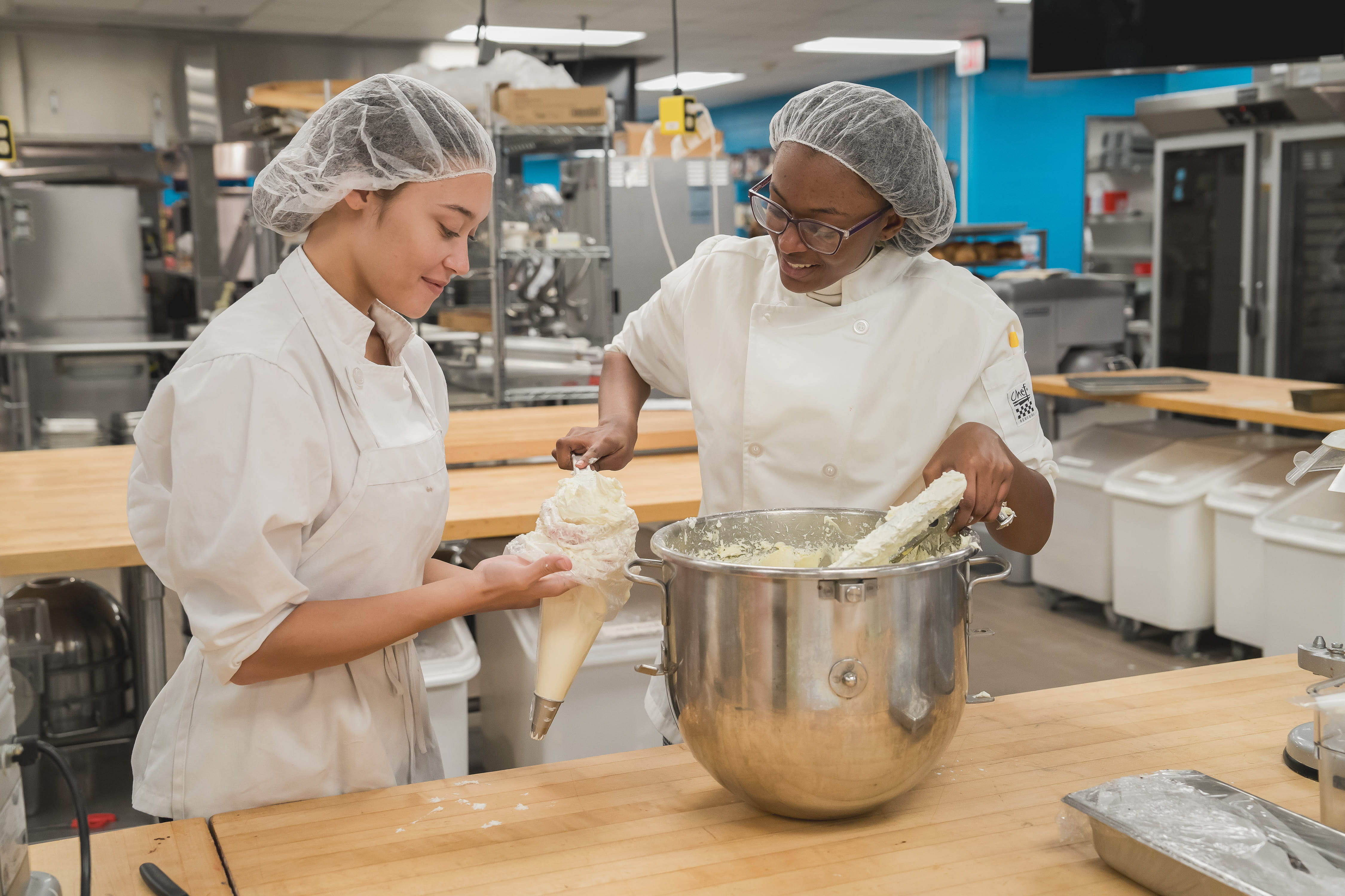 Two culinary arts students making a batter.