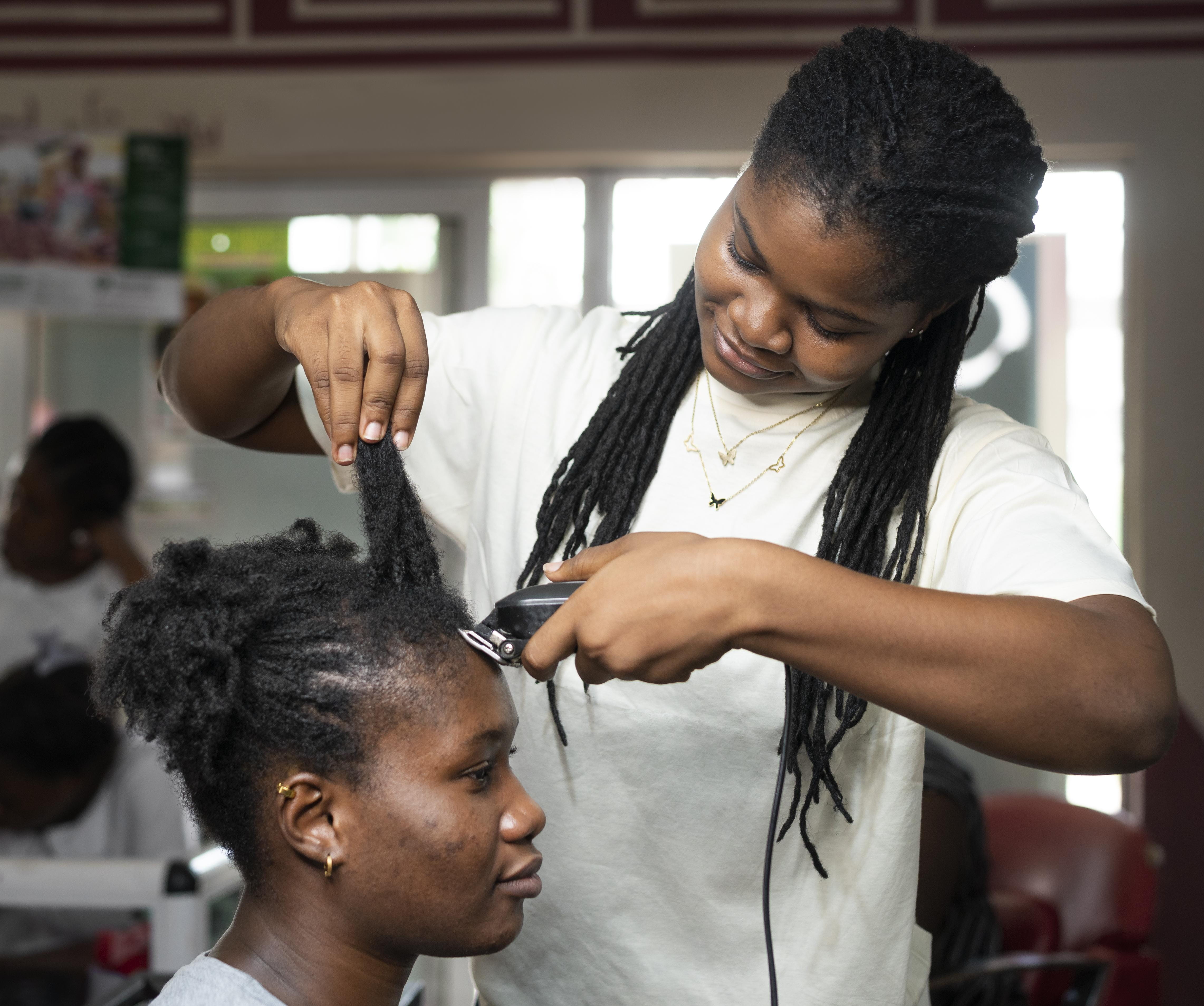 student cutting hair