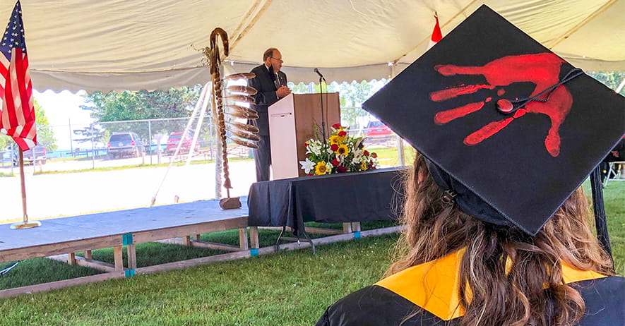 Indigenous Graduate with Red Hand Print on Mortarboard 