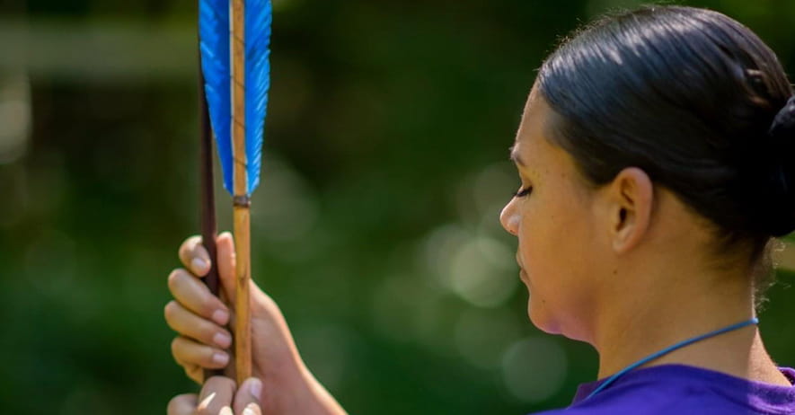 Native woman loading arrow