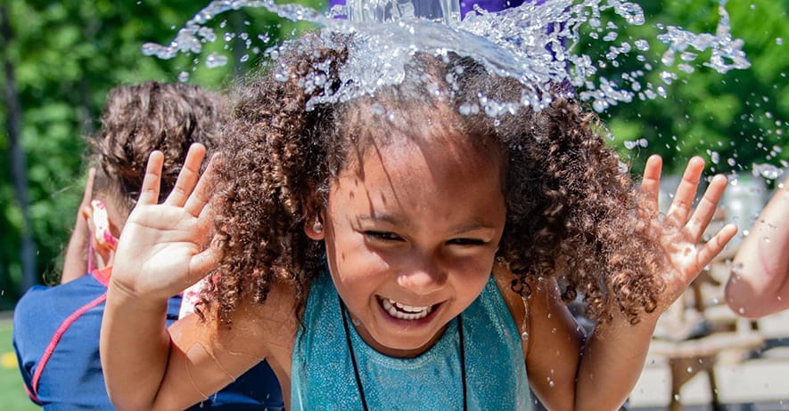 Young Native girl playing in water.