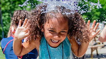 Social Studies icon showing young native girl enjoying playing in water